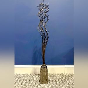 Decorative silver vase embossed in geometric shapes with tall swirling shoots